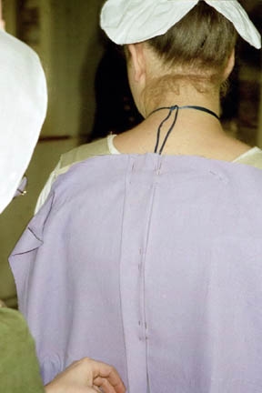 Pin-fitting and draping back of gown to foundation lining. Pin-fitting and draping back of gown to foundation lining.